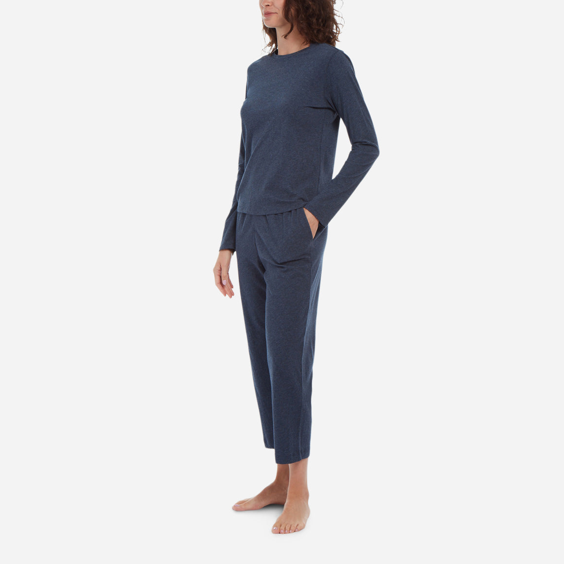 Side facing model wearing a long sleeve crewneck top with cropped pant in midnight colorway.