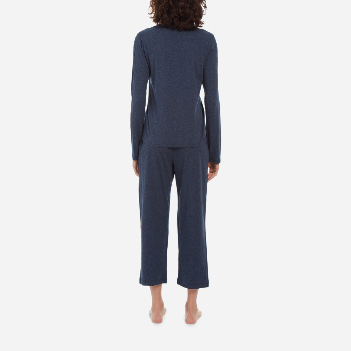 Back facing model wearing a long sleeve crewneck top with cropped pant in midnight colorway.