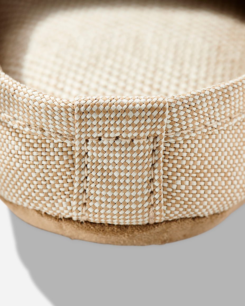 Up-close image of the heel of a beige color room slipper.