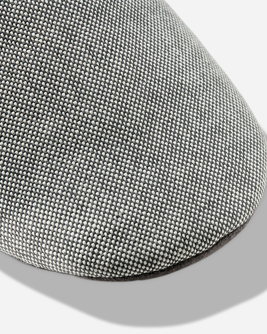 Up-close image of the toe box of a light grey room slipper.