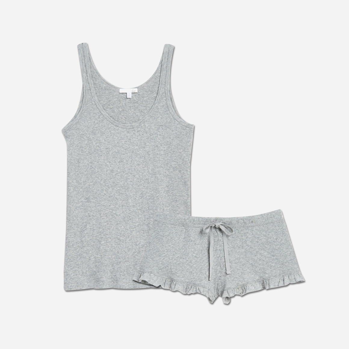 The design of the Raisa & Raffaela Set is as elegant as it is versatile. The classic fitted tank top has a flattering scoop neckline, while the cozy shorts offer a comfortable, yet flattering silhouette with an adorable ruffled edge. The elastic waistband with drawstring ensures a personalized fit for all body types.