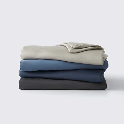 Stack of folded towels in gray, blue, and black on a white background