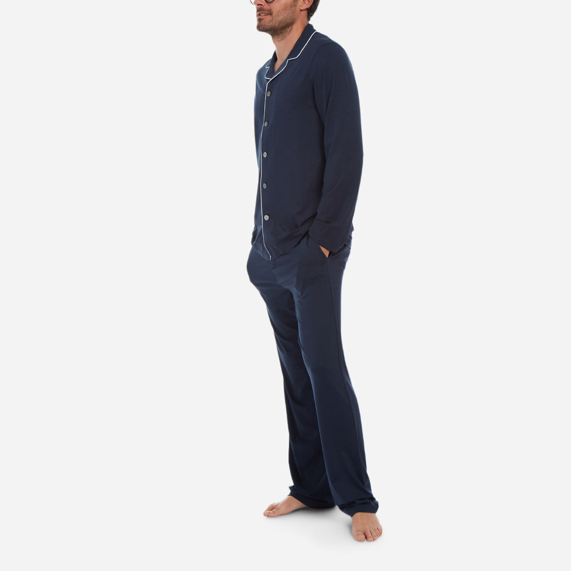 A side-facing model is wearing a long pajama set made of navy micro modal fabric.