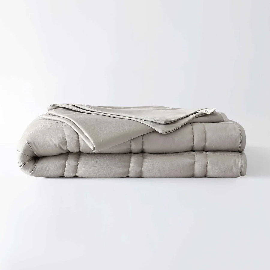 Folded gray comforter on a white background