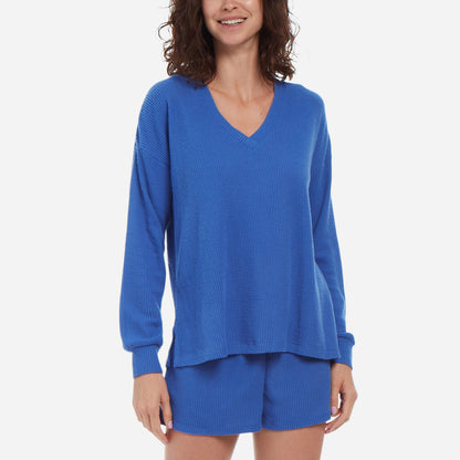 Front-facing female model wearing a long-sleeve top and shorts waffle knit lounge set in royal blue.