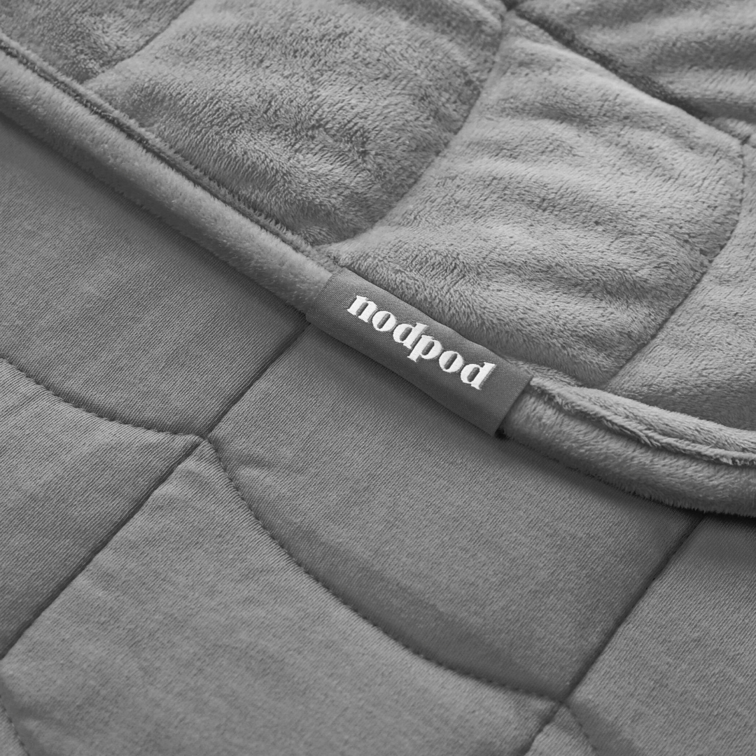 Gray quilted weighted blanket with 'nodpod' label