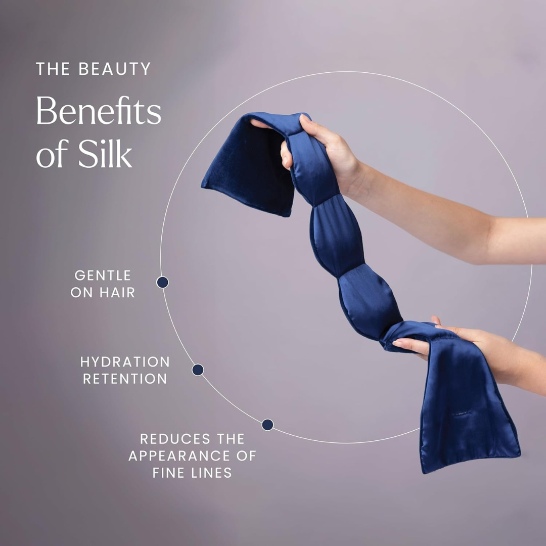 Hand holding a blue silk weighted eye mask with text about the benefits of silk on a gray background