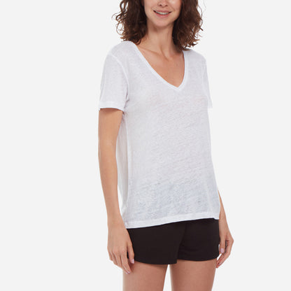Side-facing model wearing a white linen v-neck tee and black shorts.