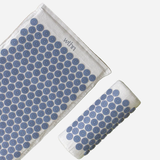 Two white towels with blue circular patterns on a green background, branded 'whrn'.