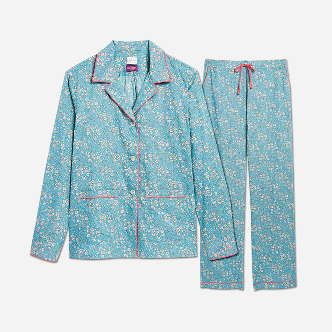 The pajama set includes a classic button-up top with a collar, two patch pockets, and functional button cuffs. The matching pair of pants features a comfortable elastic waistband, drawstring, and side-seam pockets. The long sleeves offer extra coverage and warmth for cooler evenings. 