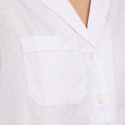Up-close image of pocket detail on white polka dot cotton jacquard pajama top.