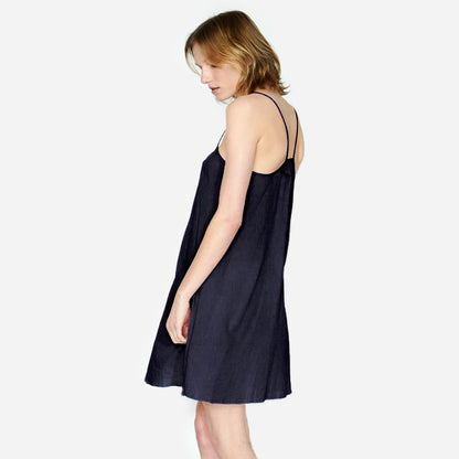 Airy Cotton Mini Slip dress in navy on model side facing, semi-sheer dress with spaghetti straps and round ballet neckline. 