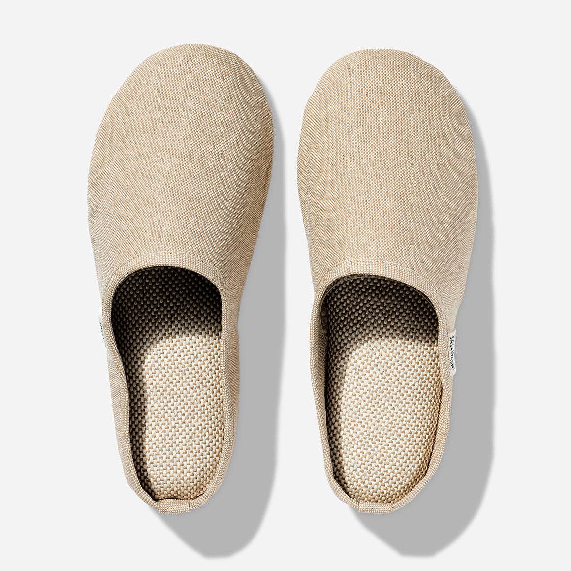 Japanese-style room slippers in beige colorway photographed against a white background. Each slipper has Saswashi written on tag near foot opening.