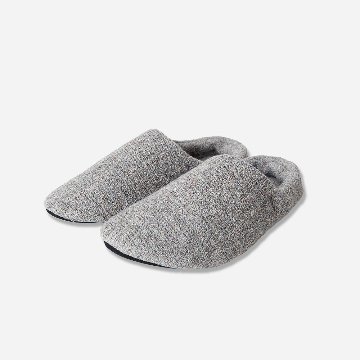 Angled view of grey slippers against white background.