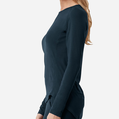 Dagsmejan’s Balance Sleep Long Sleeve Top in dark blue on a female side-facing model with extended back hem.