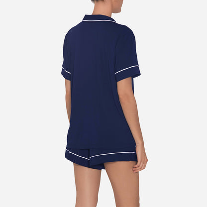The timeless design of the Gisele Shortie Short Pajama Set is accentuated by its tailored cut and refined detailing. The delicate contrast piping along the edges adds an understated charm, elevating the overall aesthetic. The button-down front allows for easy wearing and effortless style, while the matching shorts feature an elastic waistband that provides a customized fit.