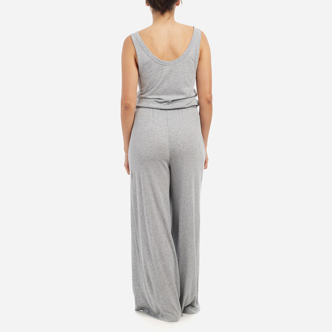 Back facing model wearing a sleeveless heather grey jumpsuit.